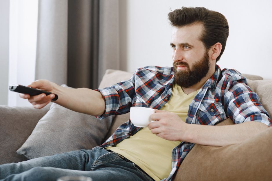happy person watching television couch relaxing